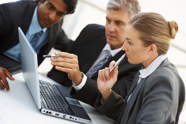 Team of business people working together on a laptop