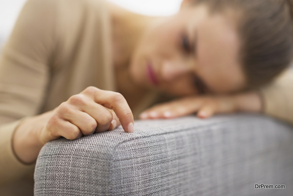 Closeup on hand of frustrated young housewife sitting on couch