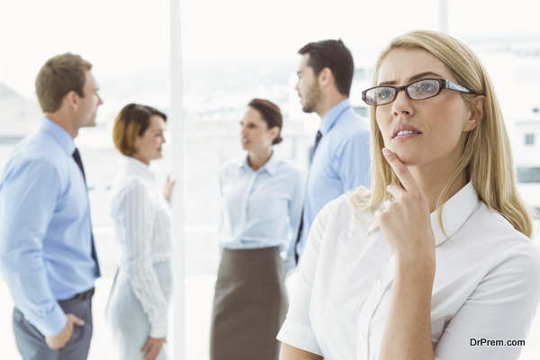 Thoughtful businesswoman with colleagues behind