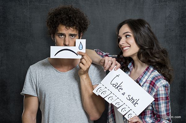 Happy Woman Looking At Man Holding Paper With Tears Drawn On It