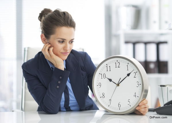 thoughtful business woman looking on clock