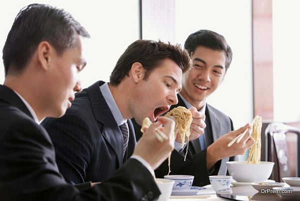 Businessmen eating noodles in restaurant