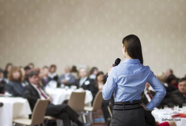 Beautiful business woman is speaking on conference.