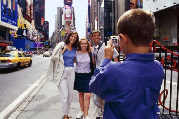 Boy taking photo of family in Times Square