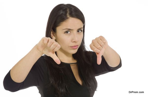 Model isolated on plain background in studio with thumbs down