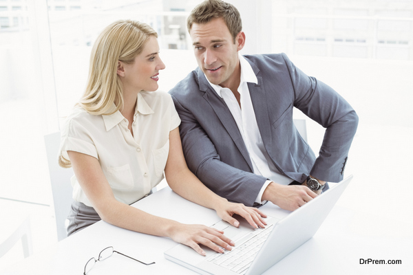 Business people using laptop in office