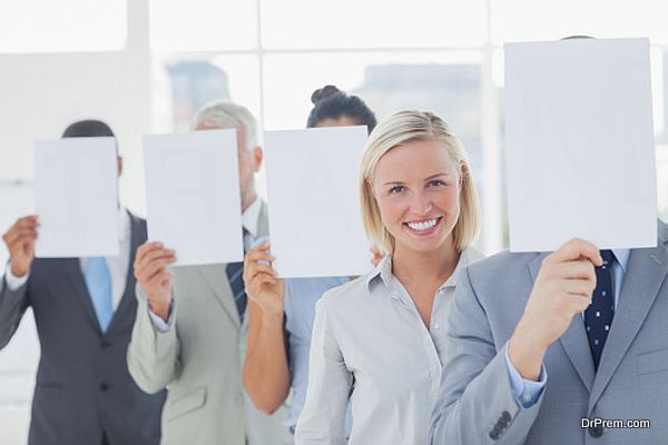 Business team covering face with white paper except for one woman