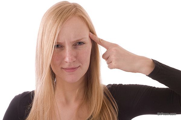 Young woman pointing her finger to her head