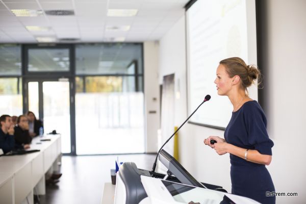 Pretty, young business woman giving a presentation in a conference/meeting setting (shallow DOF; color toned image)