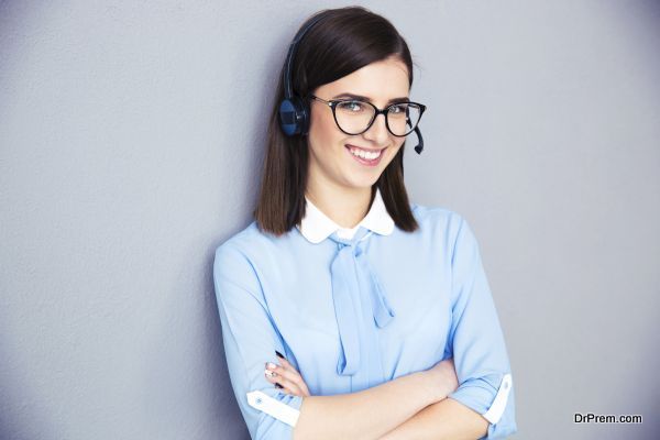 Happy businesswoman with headset and arms folded