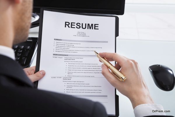 Businessman Analyzing Resume At Office Desk
