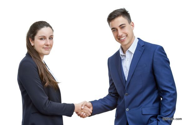 Young business couple shaking hands isolated