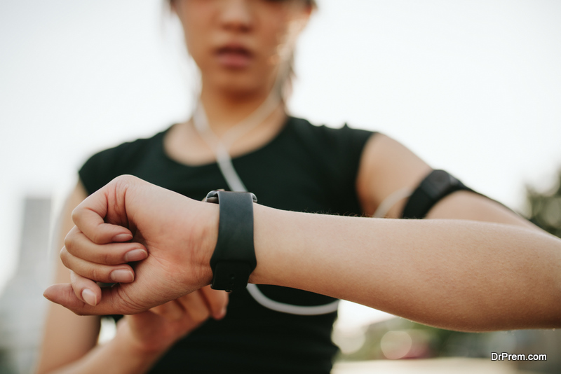 Close up shot of young sportswoman using smartwatch to track her workout performance