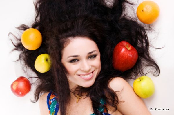 Portrait of a pretty young brunette with fresh fruits