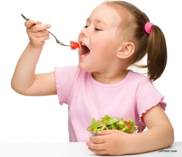 Cute little girl eats vegetable salad