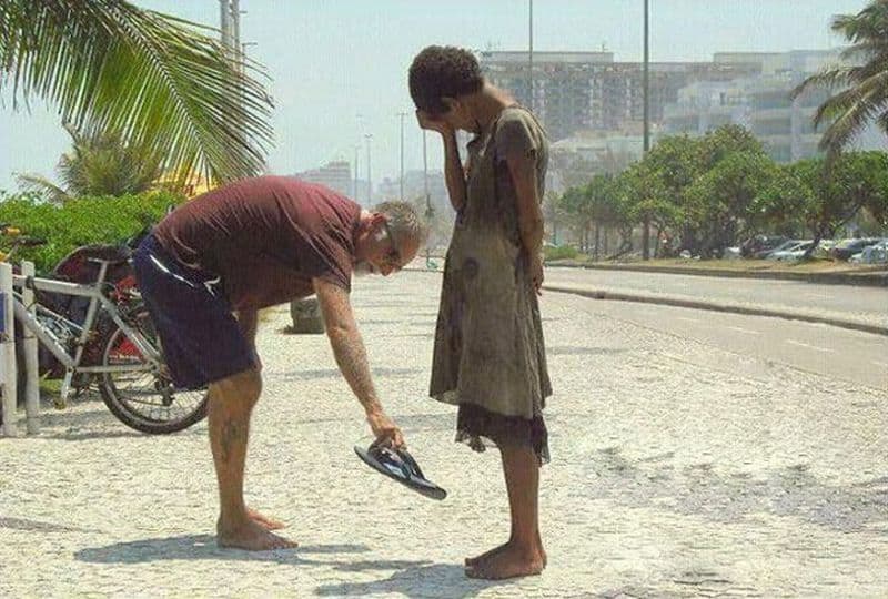 A man donates his shoes to a homeless Rio de Janeiro girl