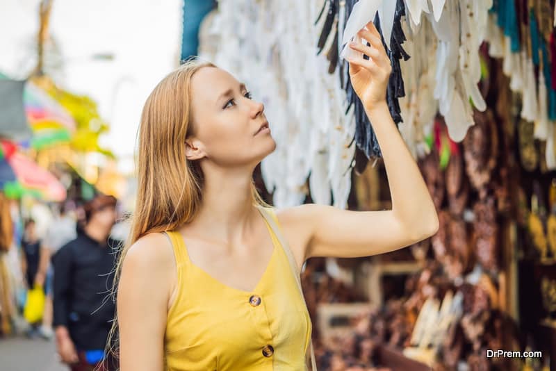 Woman traveler choose souvenirs in the market