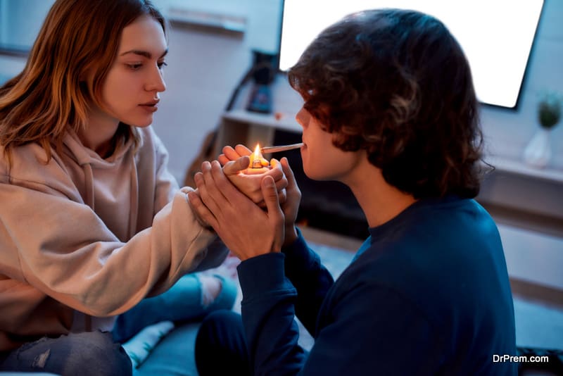 Young girl lighting cannabis cigarette