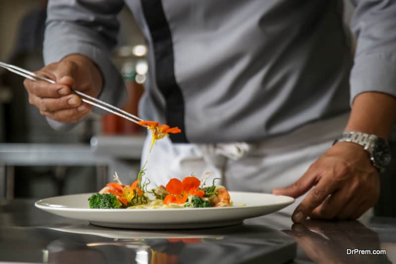 chef arranging edible flowers on the meal