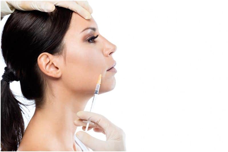 Side view of woman receiving Botox cosmetic injection in her face