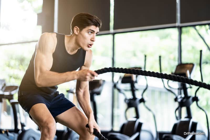 Young fit athletic sporty Caucasian man in sportswear working out in Gym or fitness club