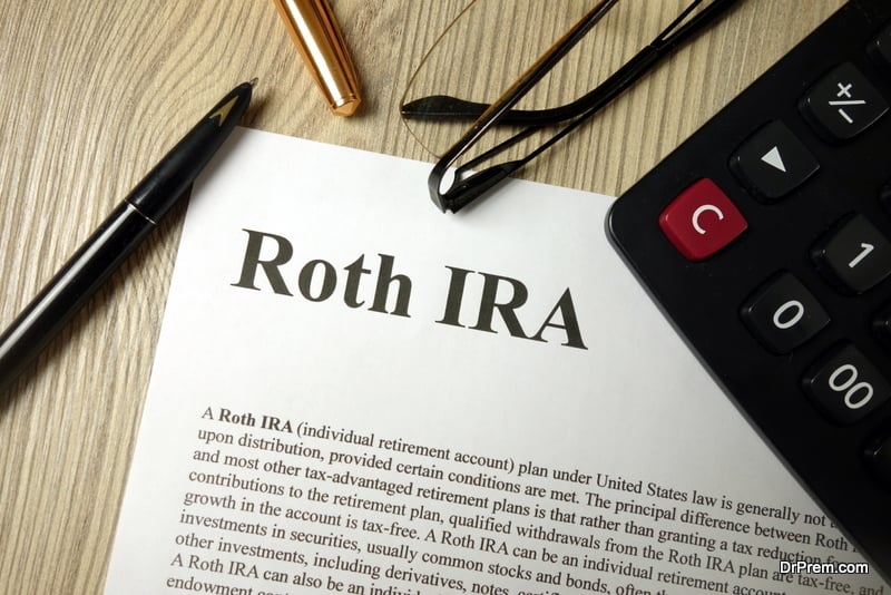 Roth IRA mockup with calculator pen and glasses, retirement planning concept