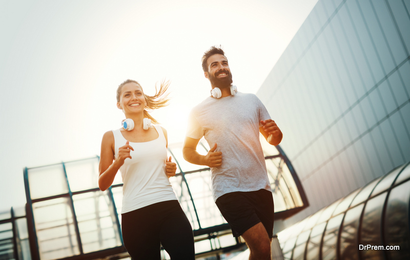 Young fitness couple running in urban area