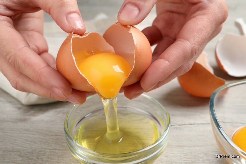 Woman separating egg yolk