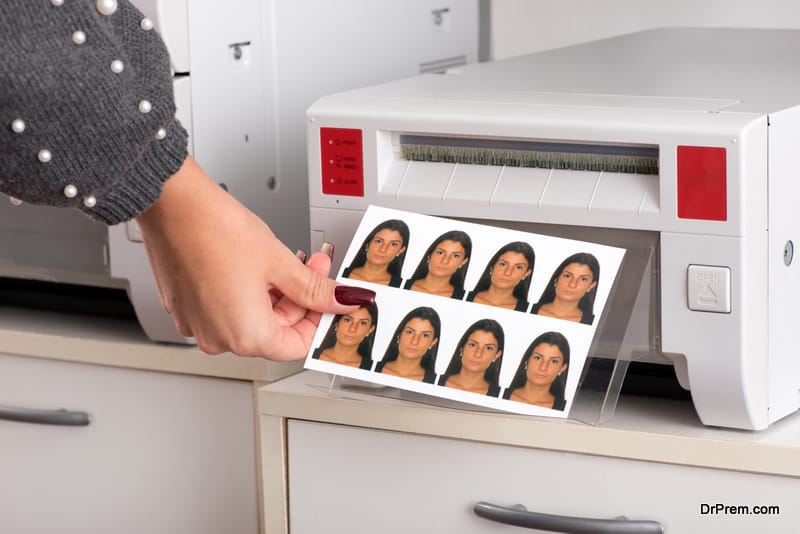Set of just printed passport photos of a young woman exiting the printer with the hand of a woman