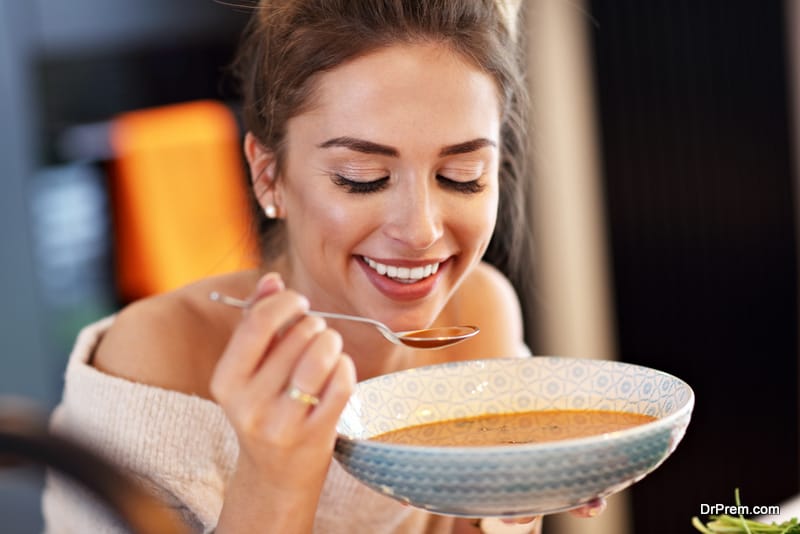 Picture of adult woman tasting soup 