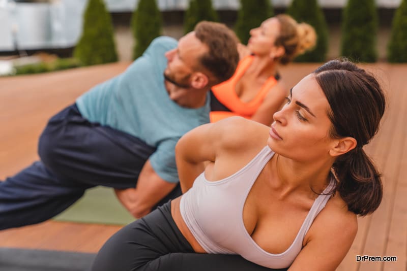 Close up shot of group of people while stretching before yoga class outdoors