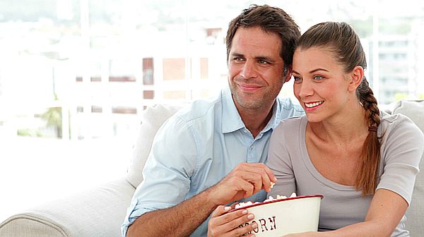 20140421195056-stock-footage-couple-watching-tv-and-eating-popcorn-on-the-couch-at-home-in-living-room