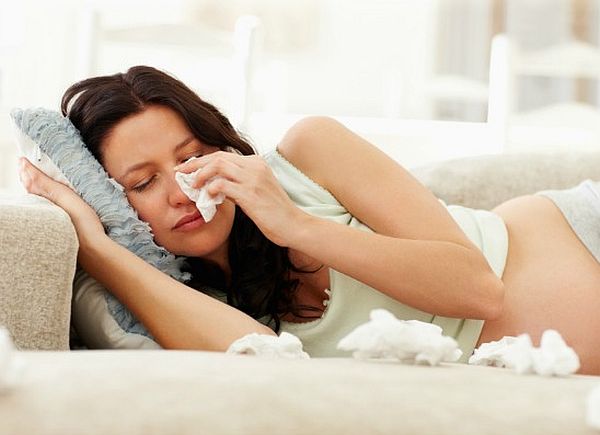 Portrait of unhappy pregnant woman crying on couch