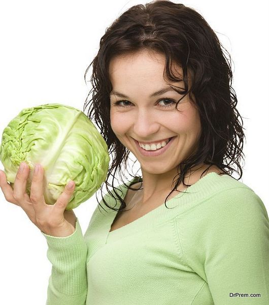 Beautiful young girl with green cabbage