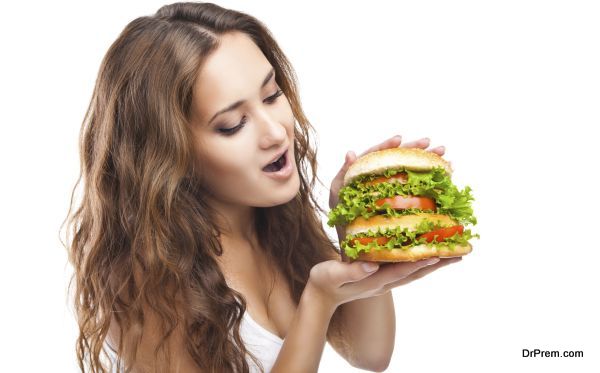 Happy Young Woman Eating big yummy Burger isolated