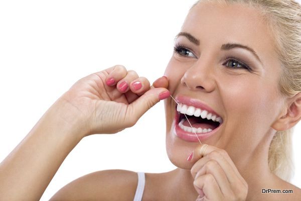 Young woman flossing her teeth , close up , isolated on white background