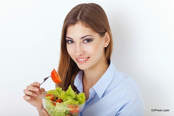 happy young woman eating a fresh salad