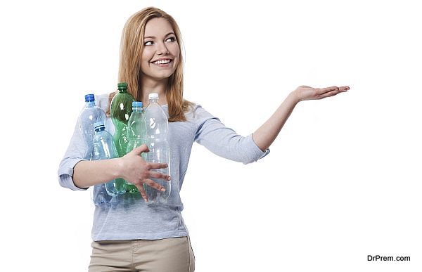 Female environmentalist with plastic bottles showing on copy space