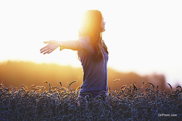 Young woman enjoying nature and sunlight in straw field