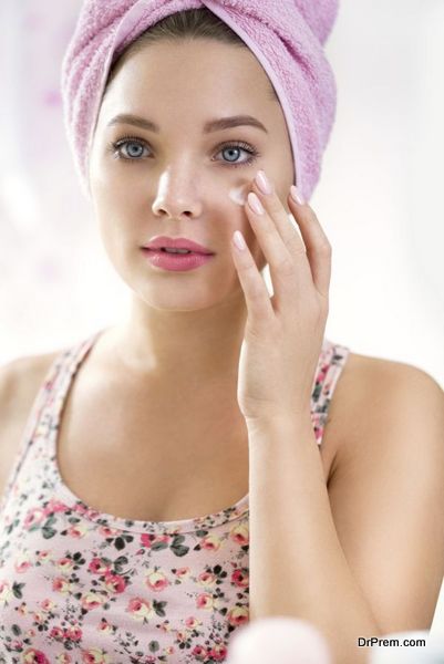 Young girl applying cream on face , skincare