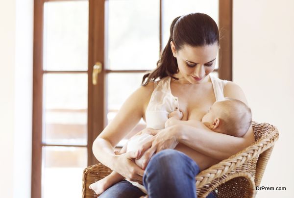 Mother breastfeeding her little baby girl in her arms.