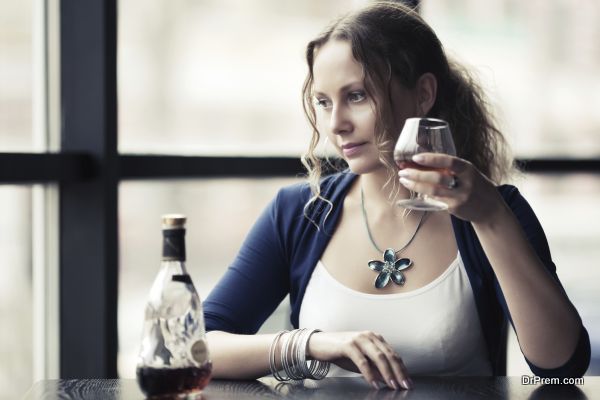 Beautiful young woman with cognac at restaurant