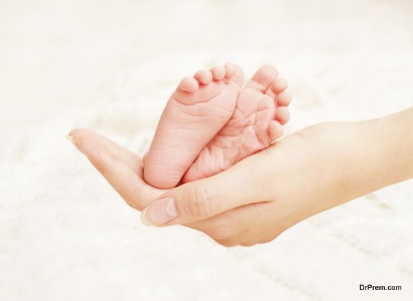 Baby Newborn Feet in Mother Hands. New Born Kid Foot, Family Love Concept
