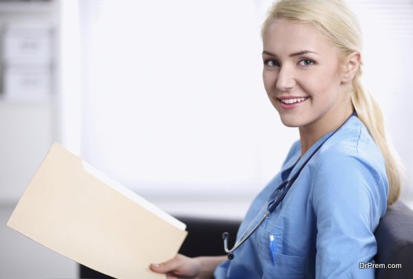 Closeup portrait of a happy young doctor sitting on the sofa with folder