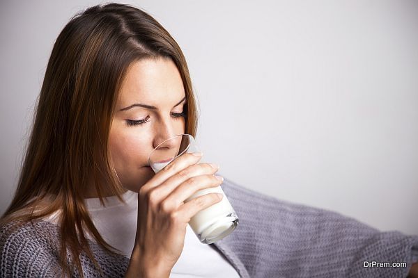 Young woman drinking a glass of milk