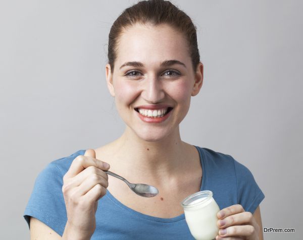 cheerful 20s girl happy to taste genuine yoghurt