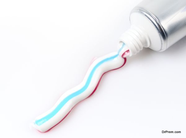 Multicolored toothpaste pouring from the tube isolated on white background.