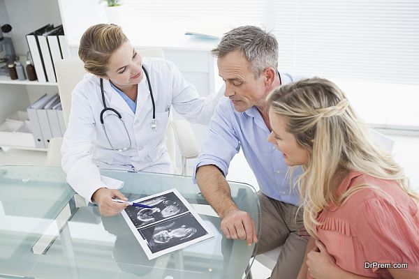 Happy couple talking to doctor