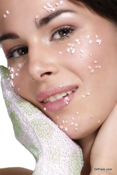 Beautiful young woman applying scrub treatment on the skin