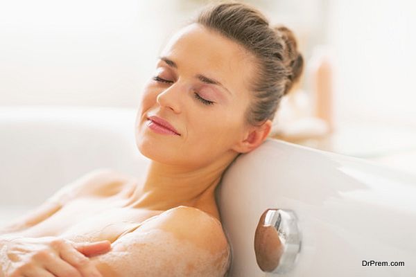 happy young woman relaxing in bathtub